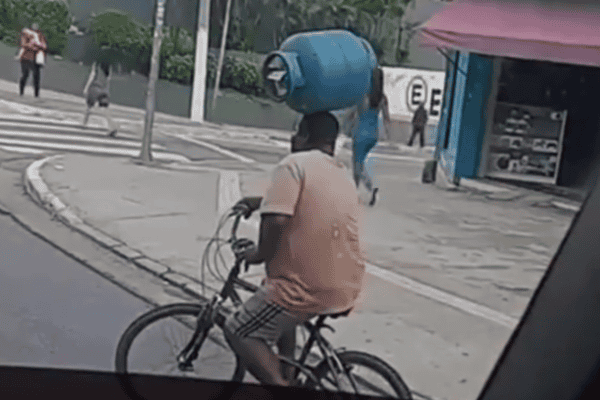 Homem chama atenção ao pedalar com botijão de gás equilibrado na cabeça